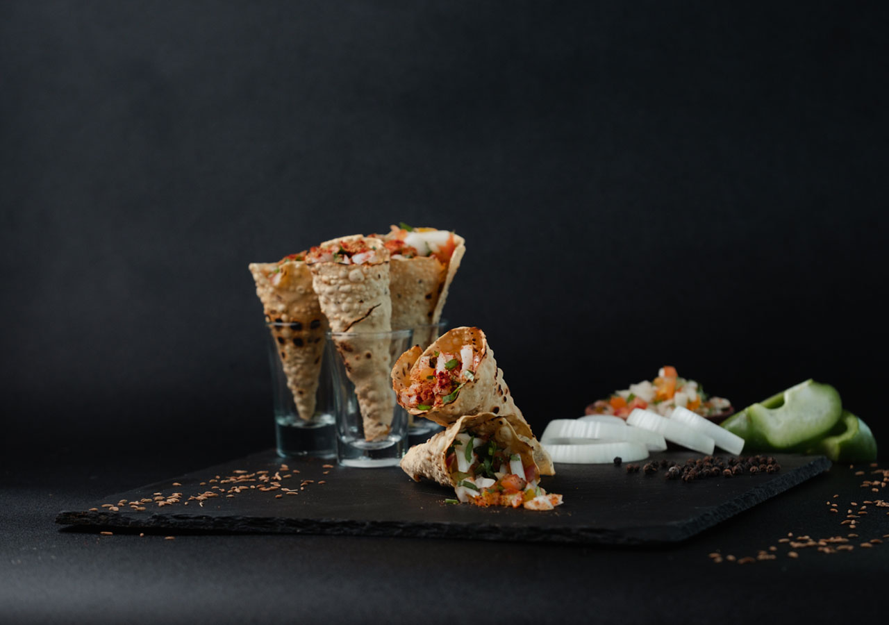 Two chefs are plating various dishes in a restaurant kitchen